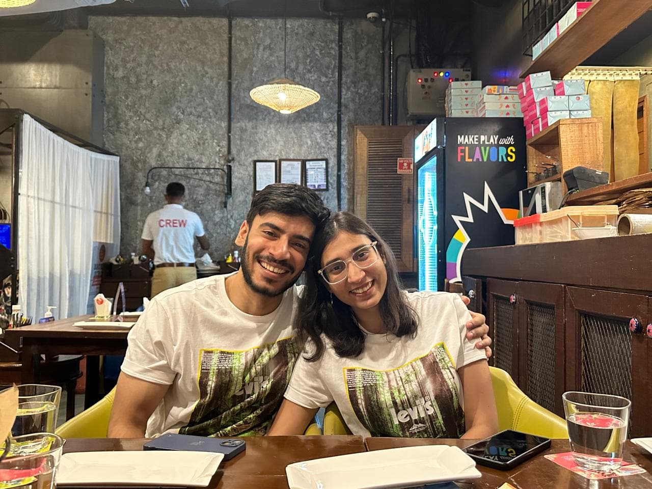 Yogi & Sudha — matching tees at restaurant